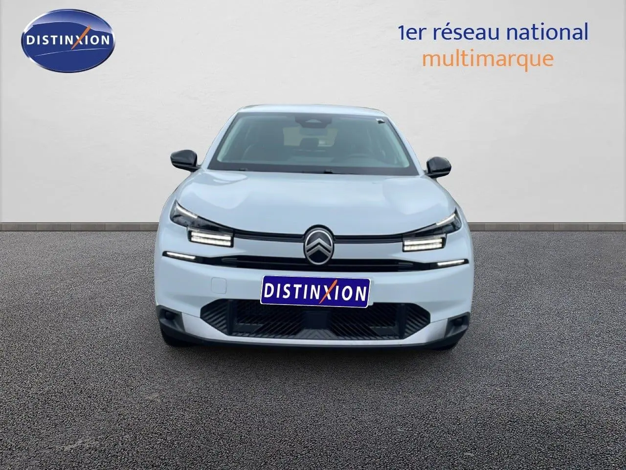 Vue frontale d'une Citroën C4 blanche métal 2026 avec calandre noire et phares LED distinctifs.