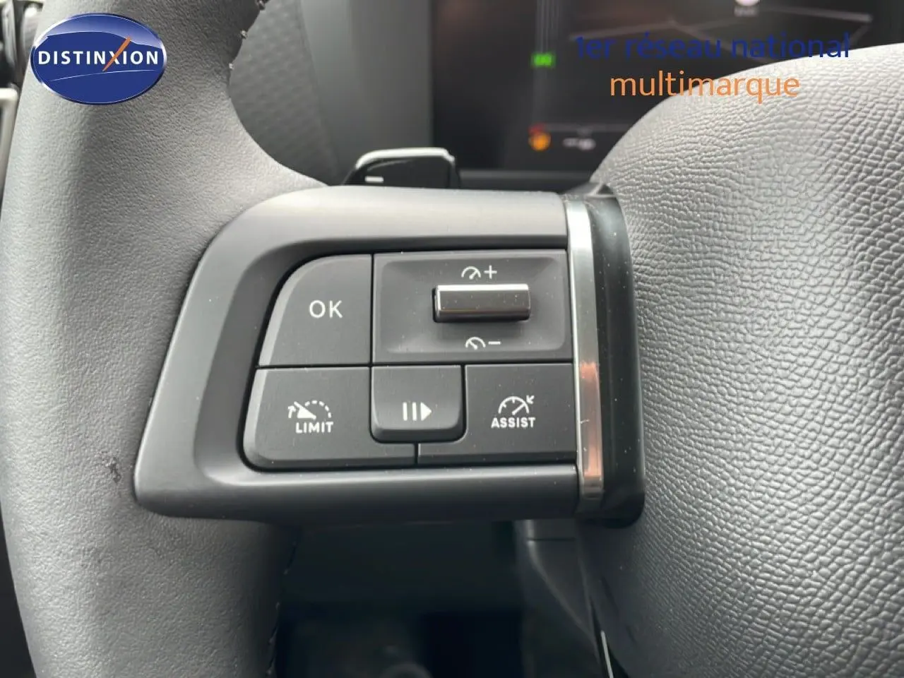 Gros plan sur les commandes de régulateur de vitesse au volant cuir noir d'une Citroën C4 blanche métal 2026.