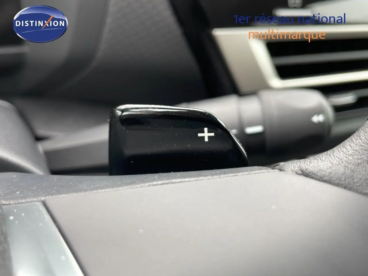 Gros plan sur la palette de changement de vitesse "+" côté droit du volant d'une Citroën C4 blanche métal 2026.