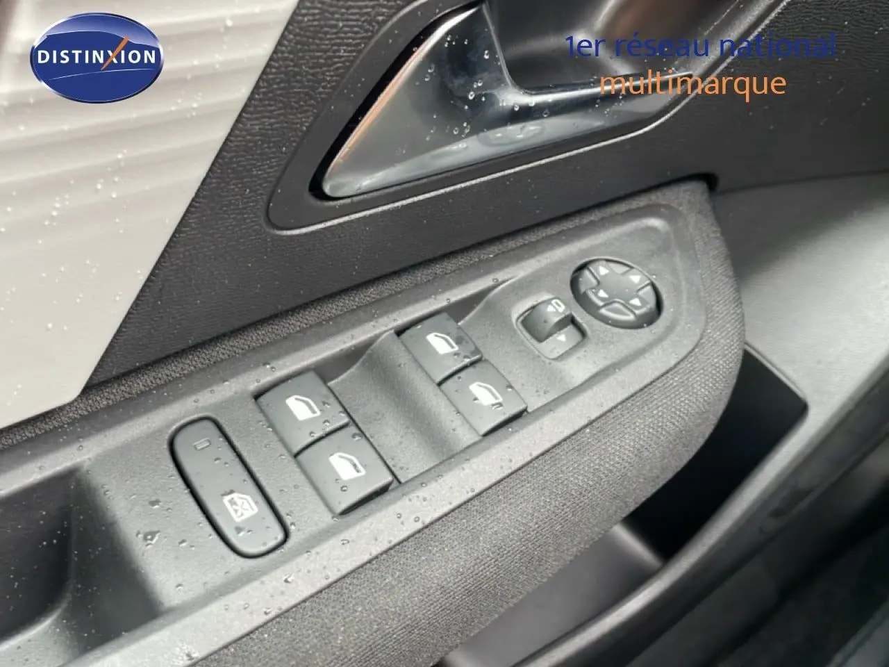 Gros plan sur les commandes des vitres et rétroviseurs côté conducteur d'une Citroën C4 blanche métal 2026.
