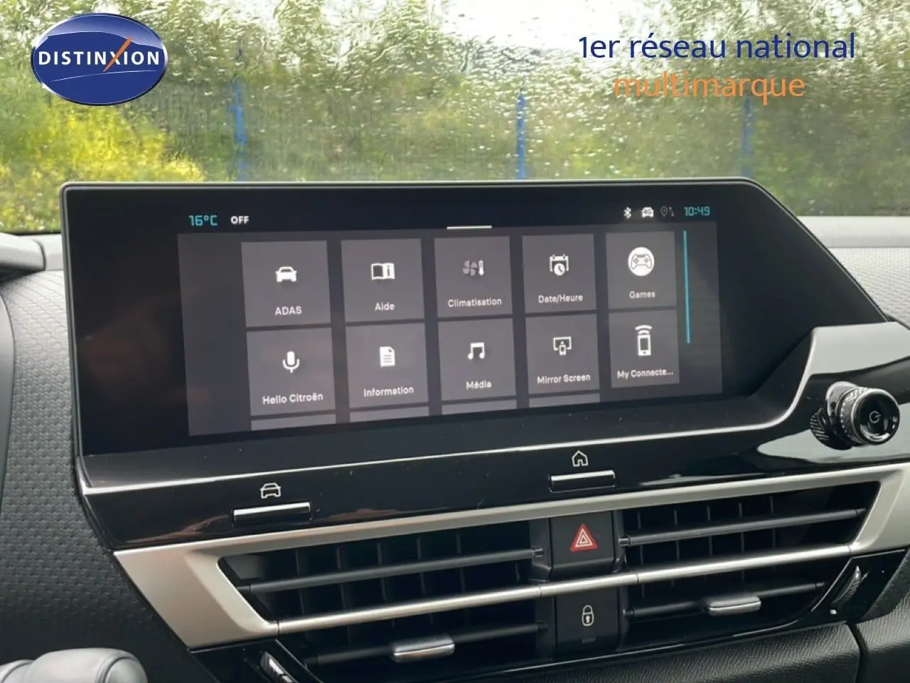 Écran tactile central affichant les options multimédia et climatisation dans le tableau de bord d'une Citroën C4 blanche.