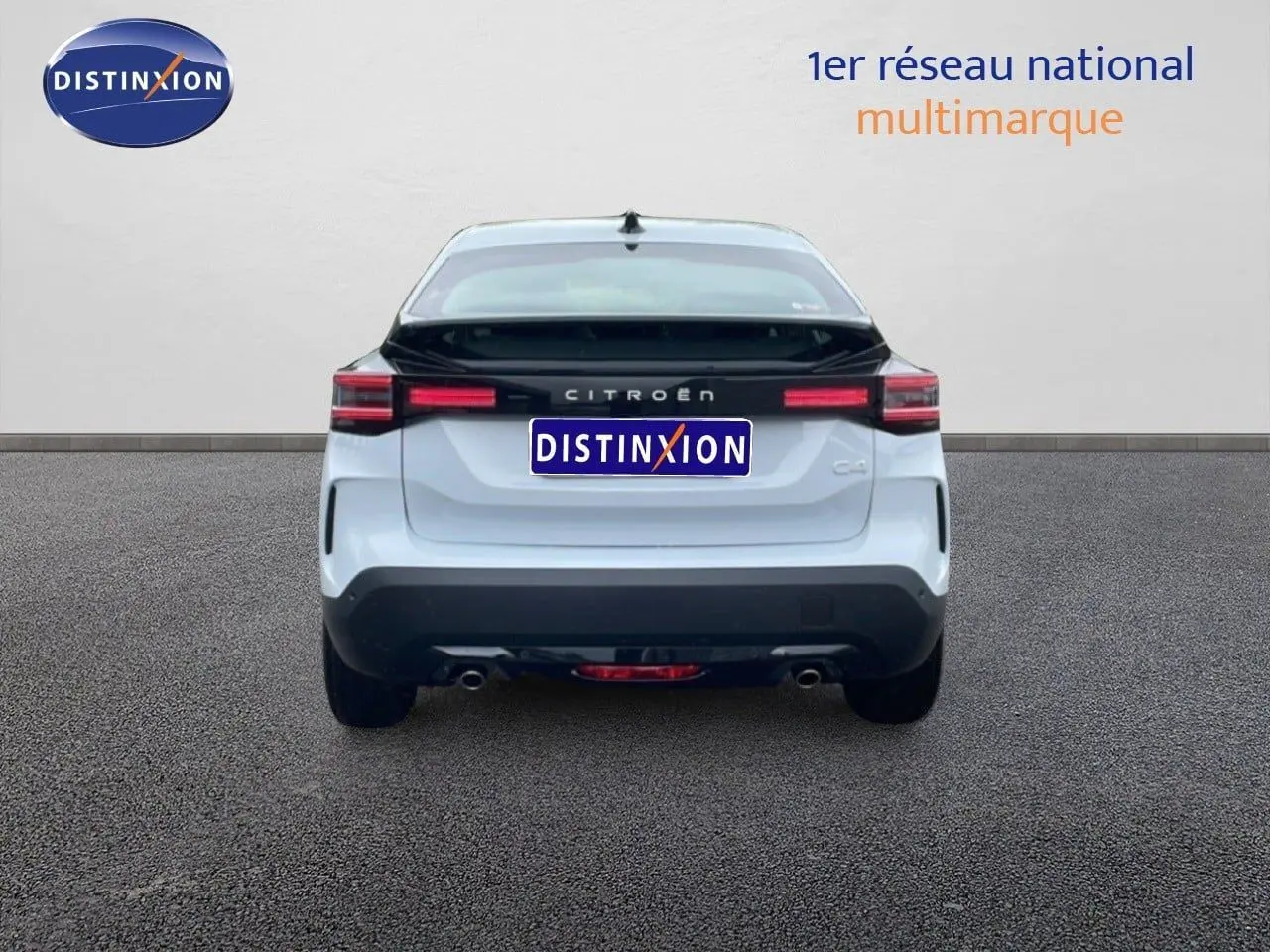 Vue arrière d'une Citroën C4 PureTech 130ch EAT8 Plus blanche métallisée avec bande noire distinctive sur le hayon.