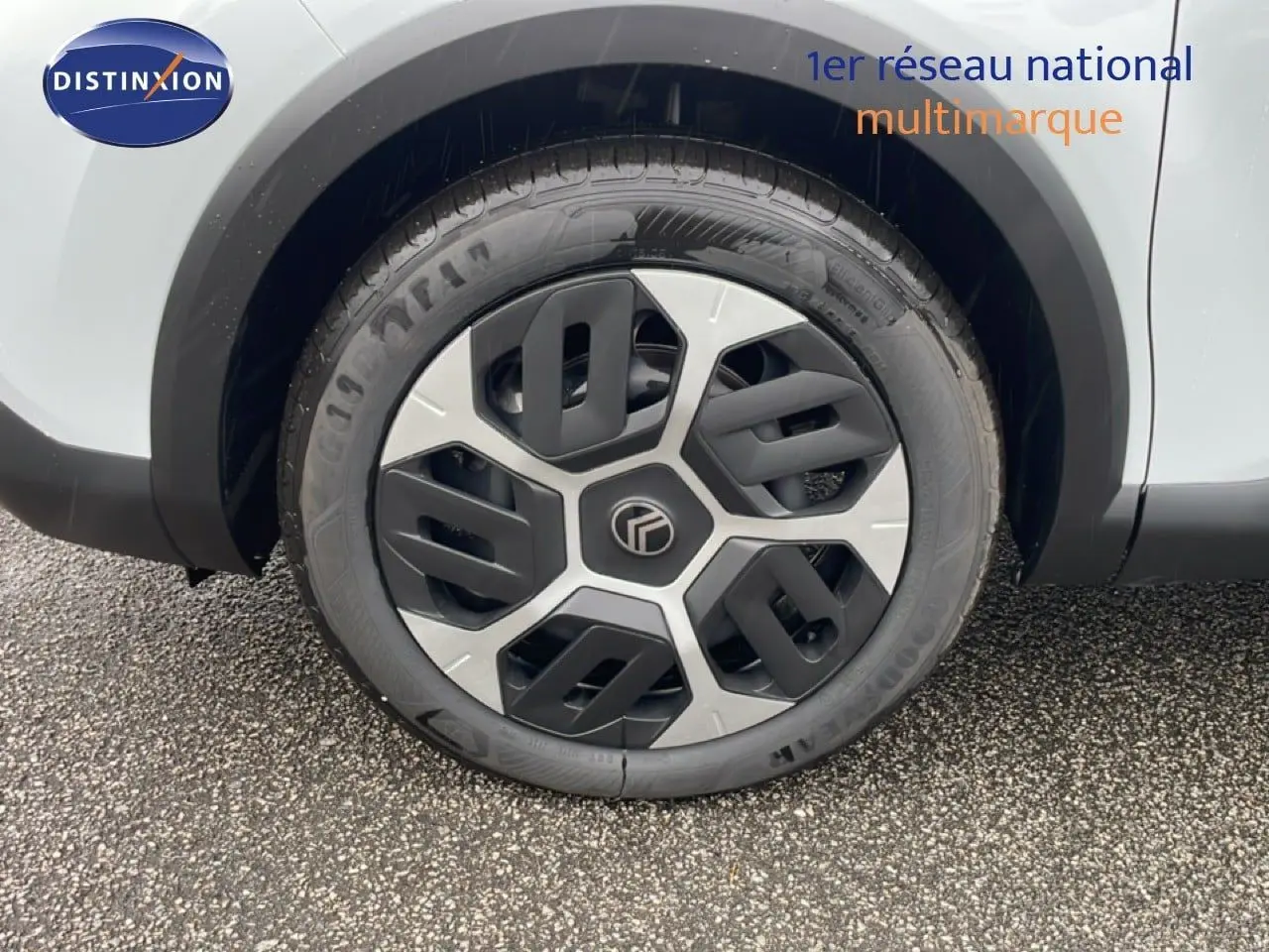 Gros plan sur la roue avant droite d'une Citroën C4 blanche métal 2026 avec jante au design moderne bicolore.
