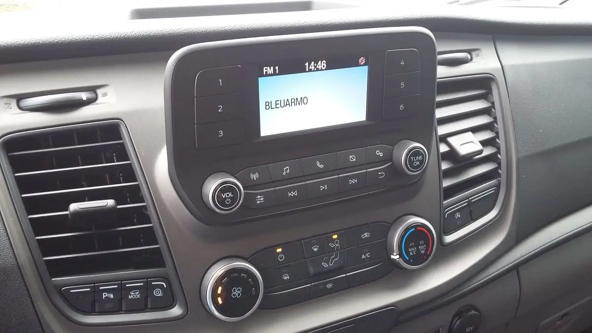 Vue rapprochée du tableau de bord du Ford Transit Fourgon 2022, avec commandes audio et climatisation visibles.