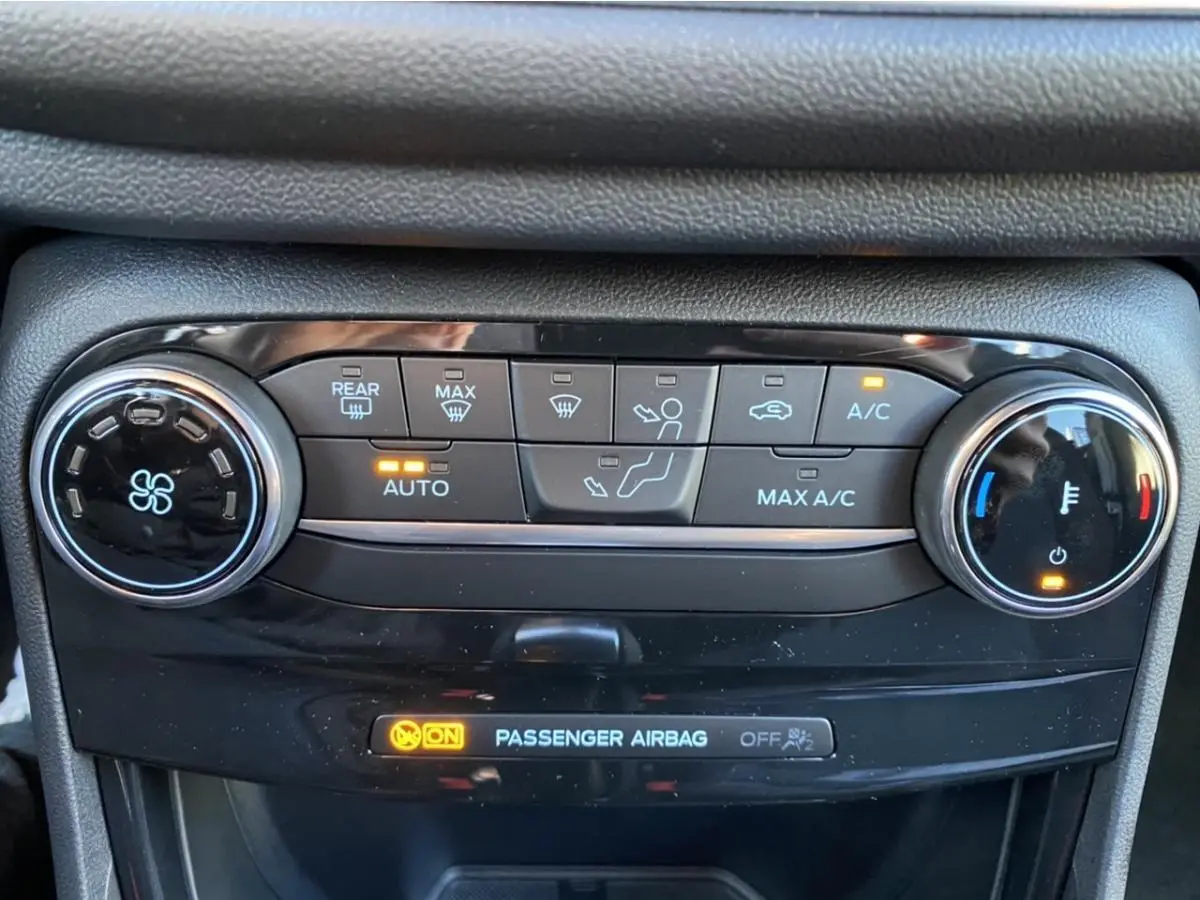 Gros plan sur la console de climatisation automatique du Ford Puma 2021 avec voyants et réglages lumineux allumés.