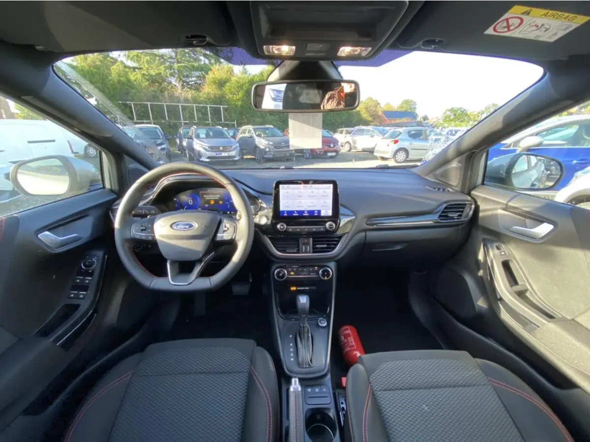 Intérieur du Ford Puma 2021 gris, vue frontale du tableau de bord avec volant multifonctions et écran tactile central.