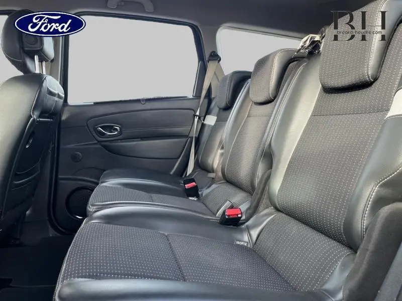 Vue latérale intérieure montrant la deuxième rangée de sièges en tissu noir étoilé du Renault Grand Scenic 2012.