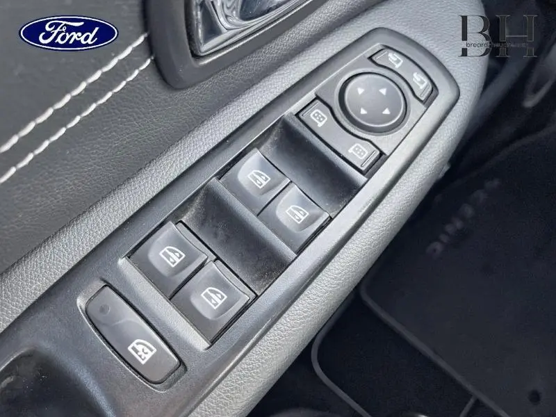 Gros plan sur les commandes des vitres électriques côté conducteur d'une Renault Grand Scenic noir étoilé, intérieur noir.