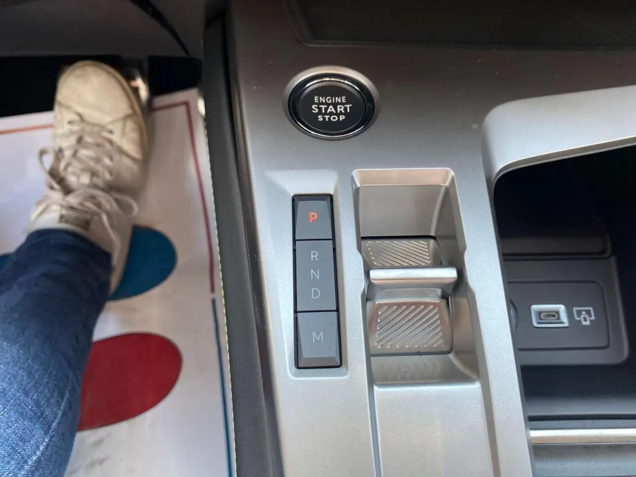 Gros plan sur la console centrale de la Peugeot 308 GT 2025 gris selenium, avec bouton start/stop et commandes de boîte auto.