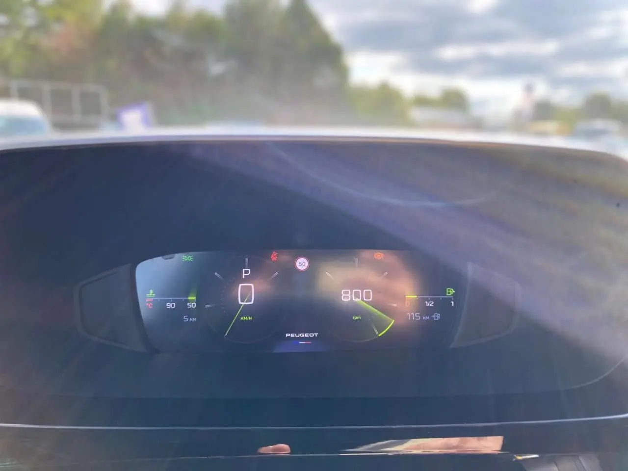 Tableau de bord numérique de la Peugeot 308 2025 affichant la vitesse, régime moteur et jauges, vue frontale intérieure.