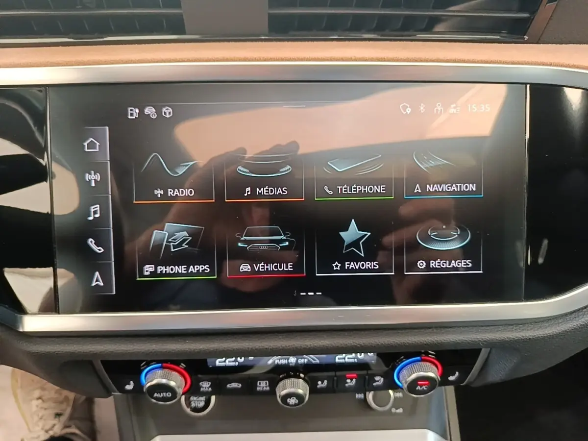 Écran tactile central de l’Audi Q3 Sportback 2024 affichant les menus multimédias et navigation, vue intérieure frontale.