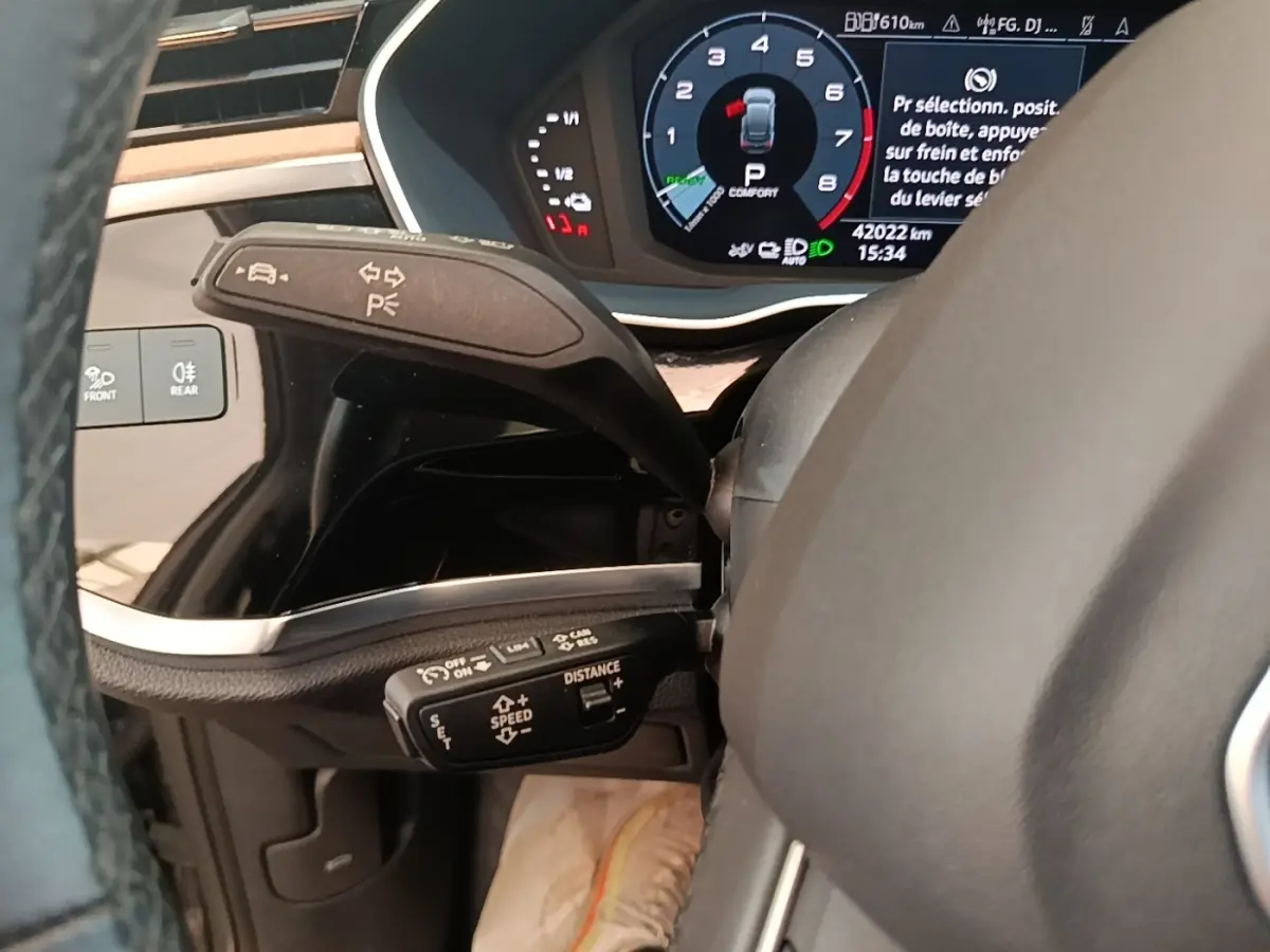 Gros plan sur le combiné d'instruments et commandes au volant de l'Audi Q3 Sportback 45 TFSI e 2024, intérieur noir.