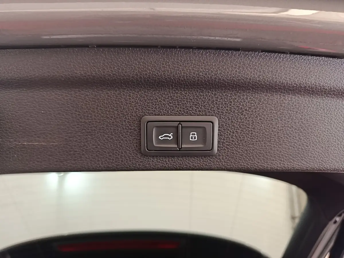 Boutons d'ouverture et de verrouillage du coffre sur la garniture intérieure du hayon d'un Audi Q3 Sportback 2024.