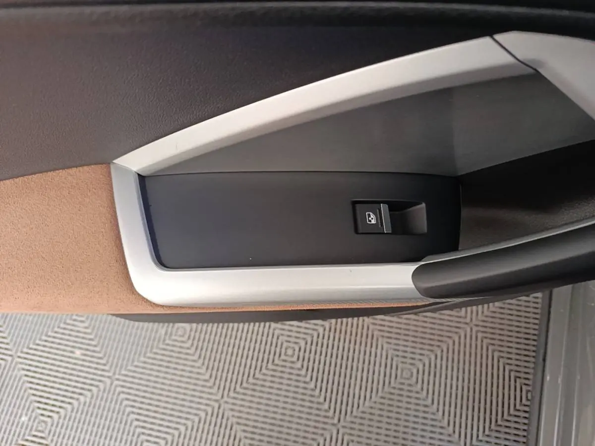 Détail de la commande de verrouillage de porte sur la garniture intérieure beige et noire d'un Audi Q3 Sportback 2024.