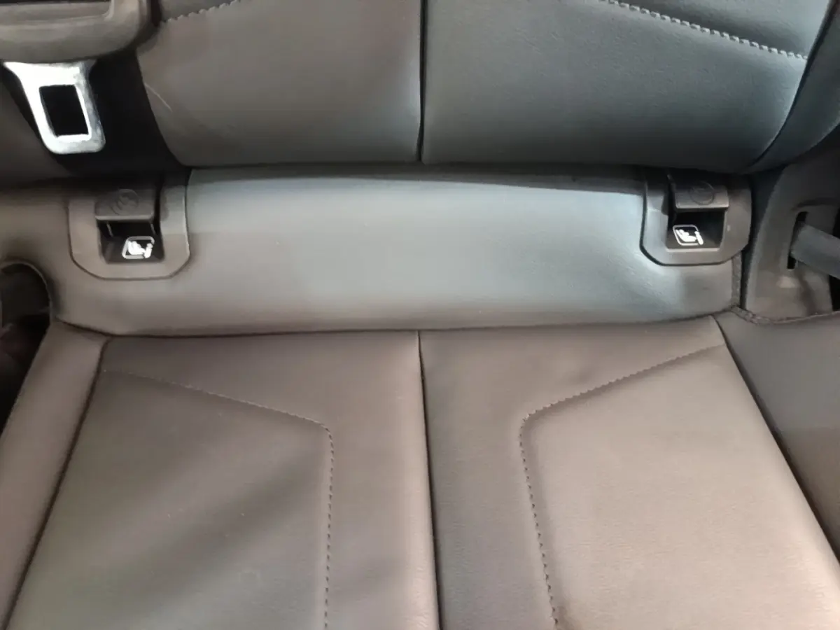 Gros plan sur la banquette arrière en cuir noir de l'Audi Q3 Sportback 45 TFSI e, avec attaches Isofix visibles.