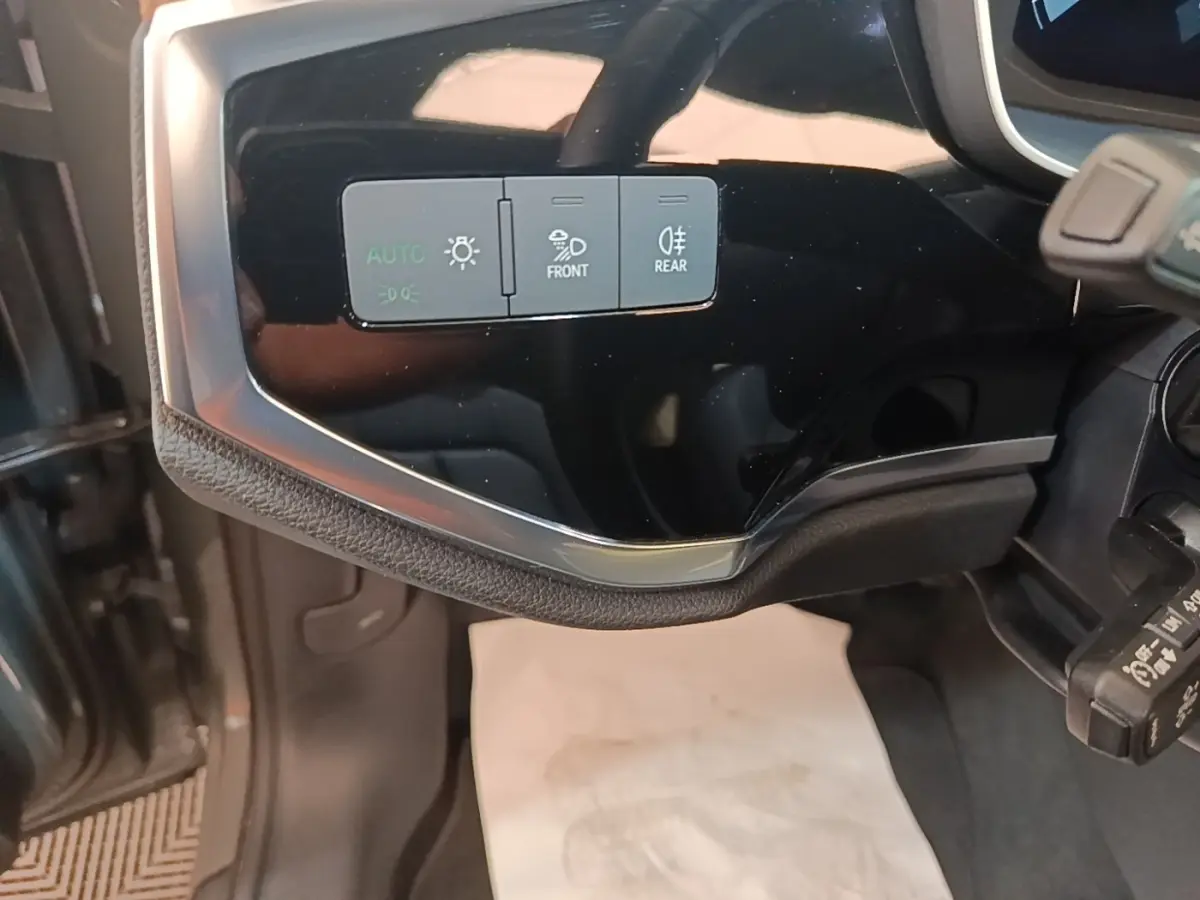 Détail du tableau de bord noir brillant côté gauche avec commandes d’éclairage sur Audi Q3 Sportback hybride 2024.