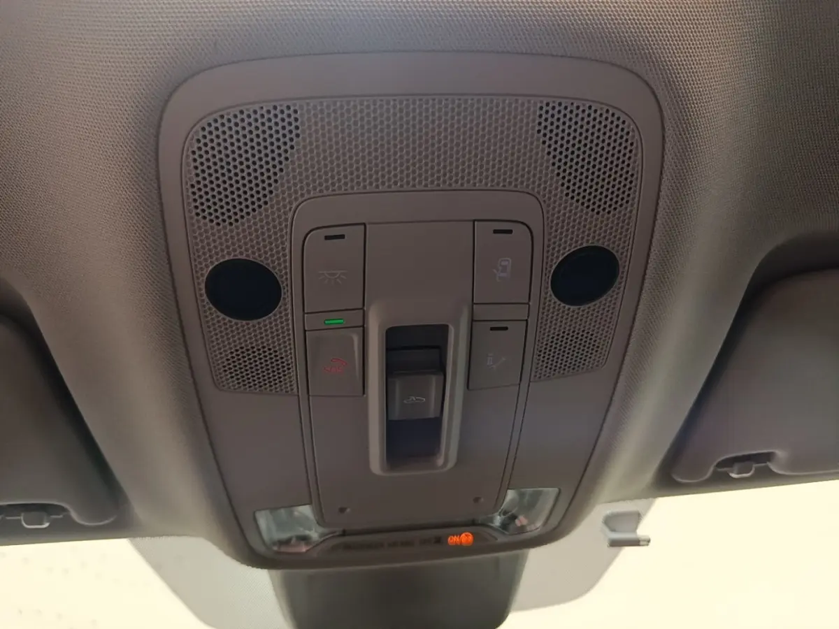 Vue intérieure du plafonnier gris clair de l'Audi Q3 Sportback 2024 avec commandes d'éclairage et bouton SOS.