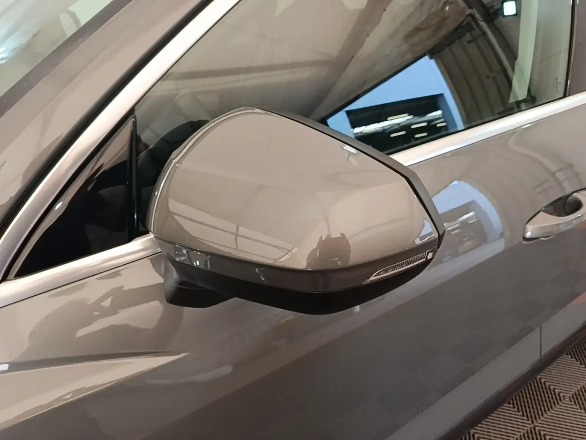 Rétroviseur côté gauche beige métallisé de l'Audi Q3 Sportback 2024 avec clignotant intégré, vue rapprochée.