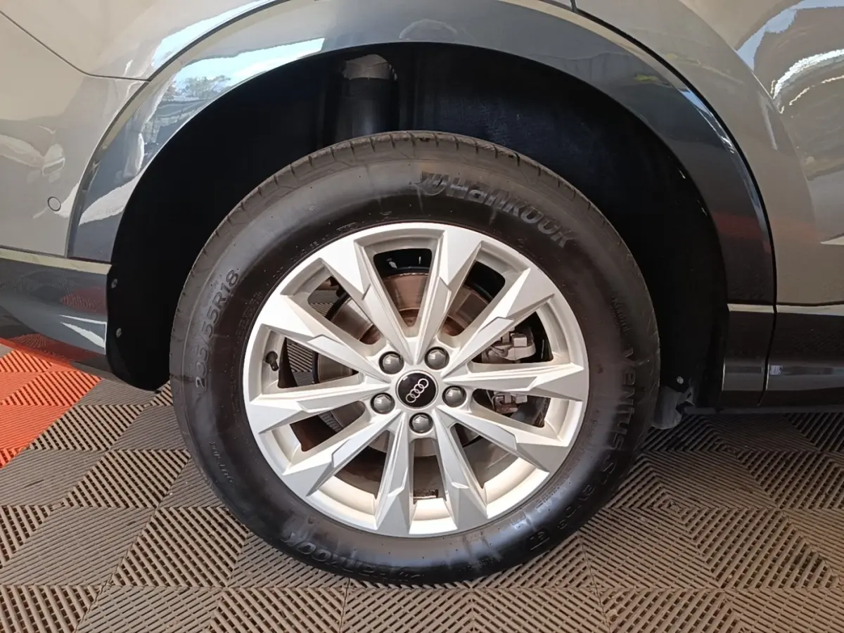 Gros plan sur la roue arrière droite grise de l'Audi Q3 Sportback 45 TFSI e avec jante argentée multi-branches.