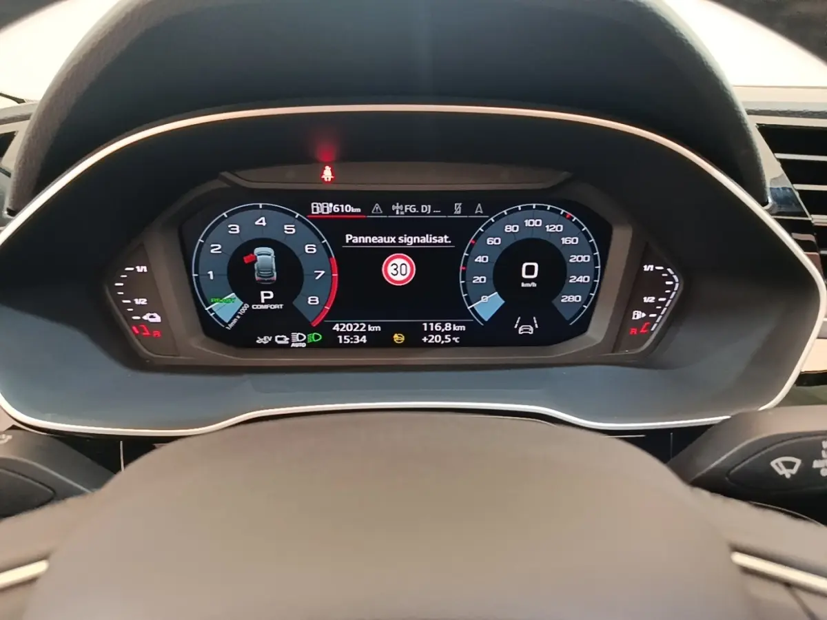 Vue rapprochée du combiné d'instruments numérique de l'Audi Q3 Sportback 45 TFSI e, affichant la vitesse et alertes.