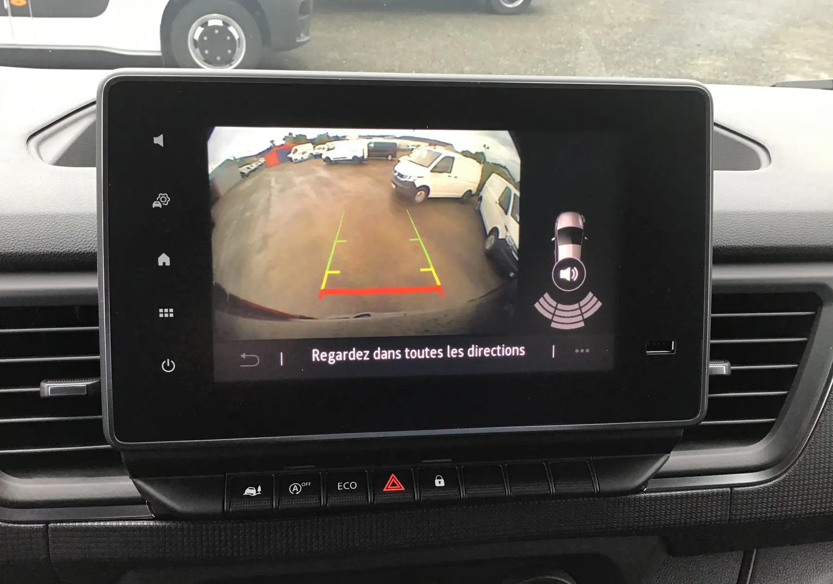 Écran central du Renault Trafic Fourgon blanc 2023 montrant la caméra de recul avec vue arrière et lignes de guidage colorées.