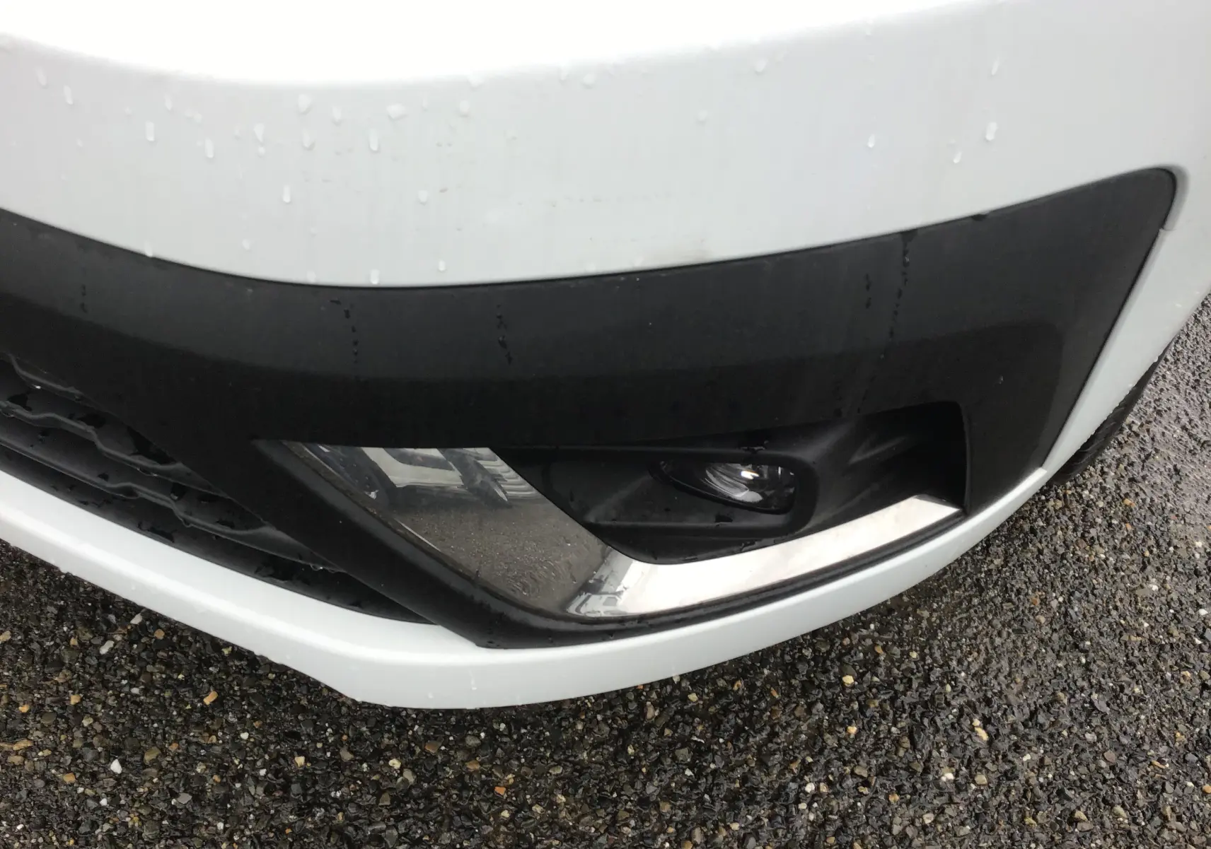 Gros plan sur le pare-chocs avant blanc du Renault Trafic Fourgon L2H1, mettant en valeur l'antibrouillard et la finition noire.