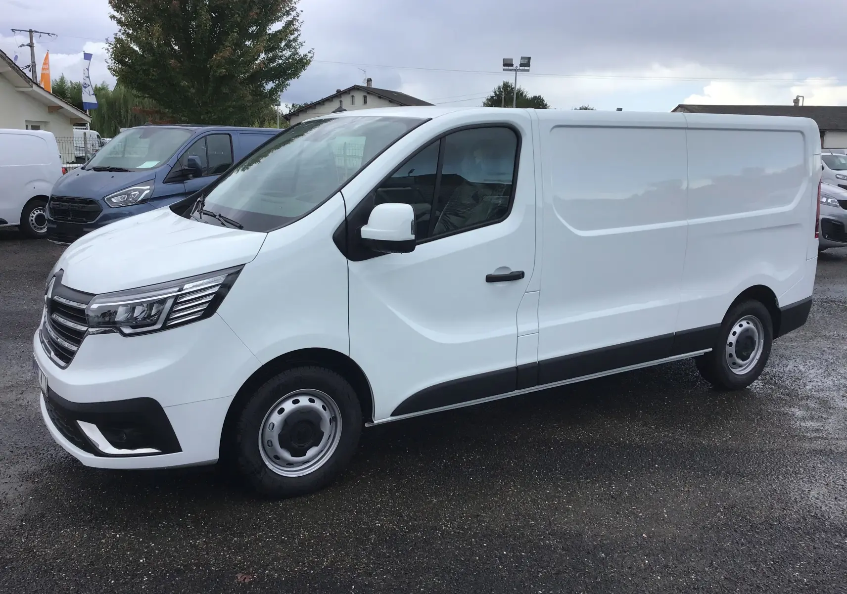 Renault Trafic Fourgon blanc vu de profil côté droit, avec calandre moderne et jantes acier simples.