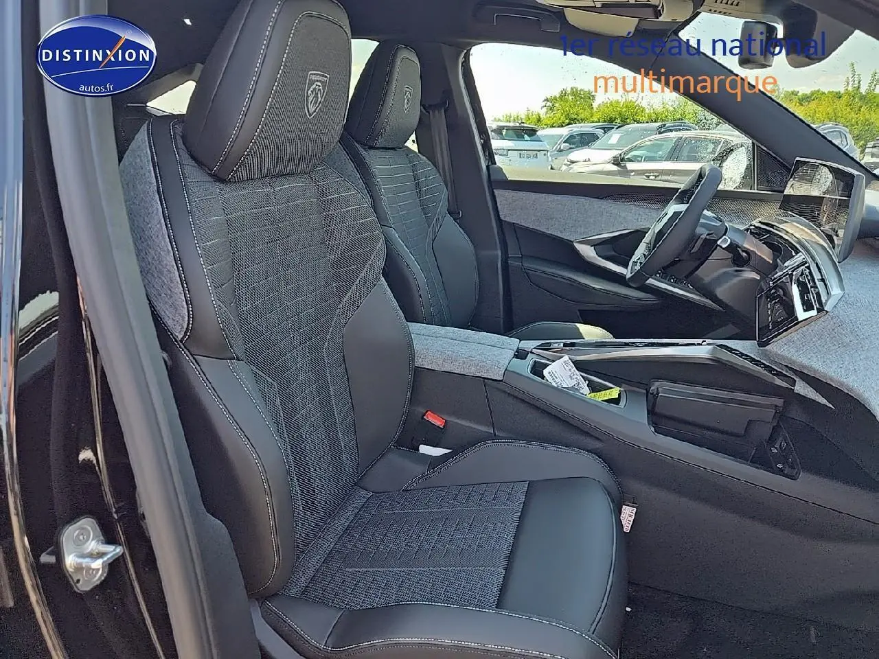 Vue intérieure côté conducteur du Peugeot 3008 2025, sièges tissu et cuir noir avec logo Peugeot brodé sur appuis-tête.