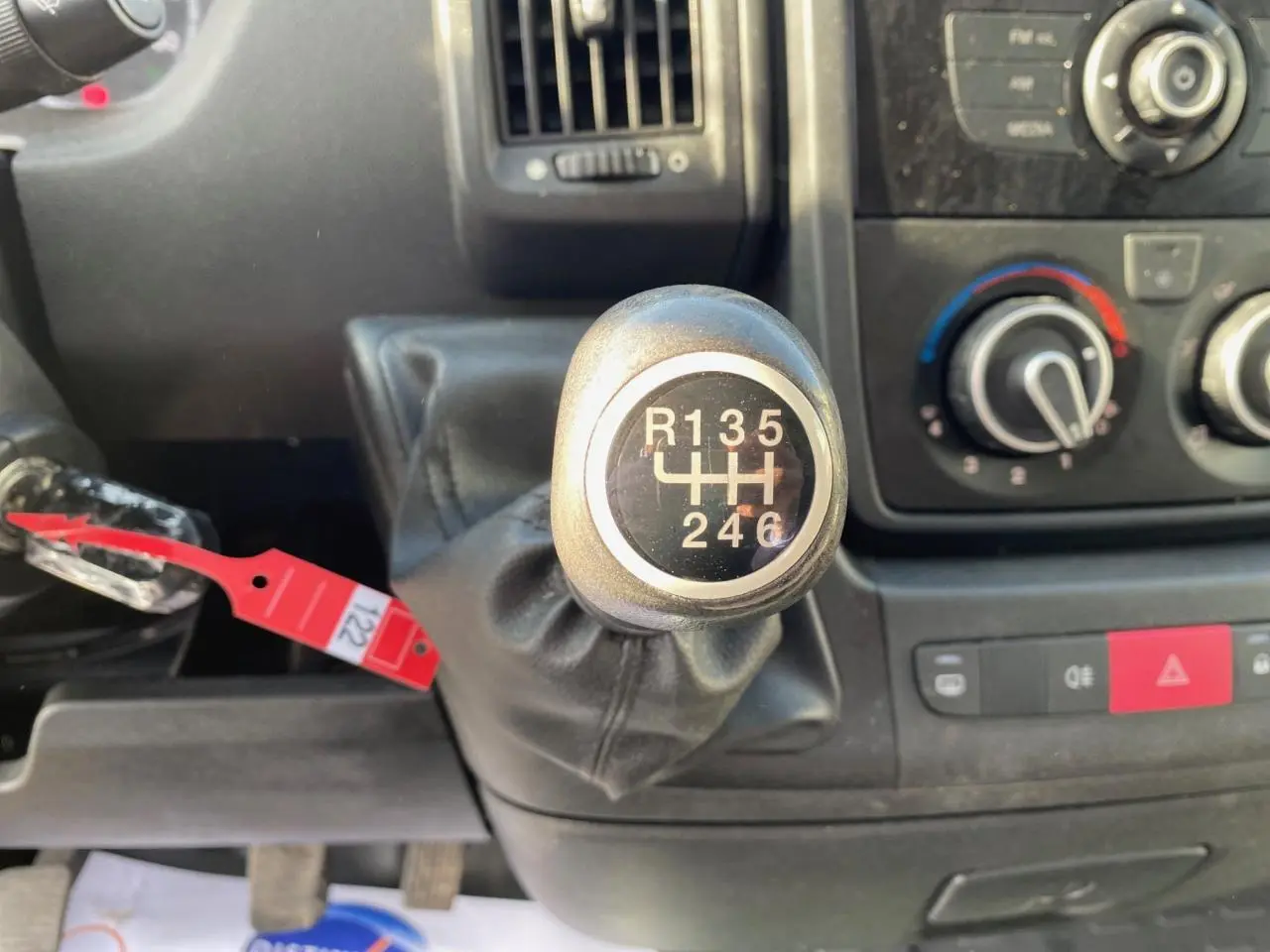 Le levier de vitesses manuel en gros plan dans l'habitacle d'un Citroën Jumper blanc, avec tableau de bord et commandes visibles.