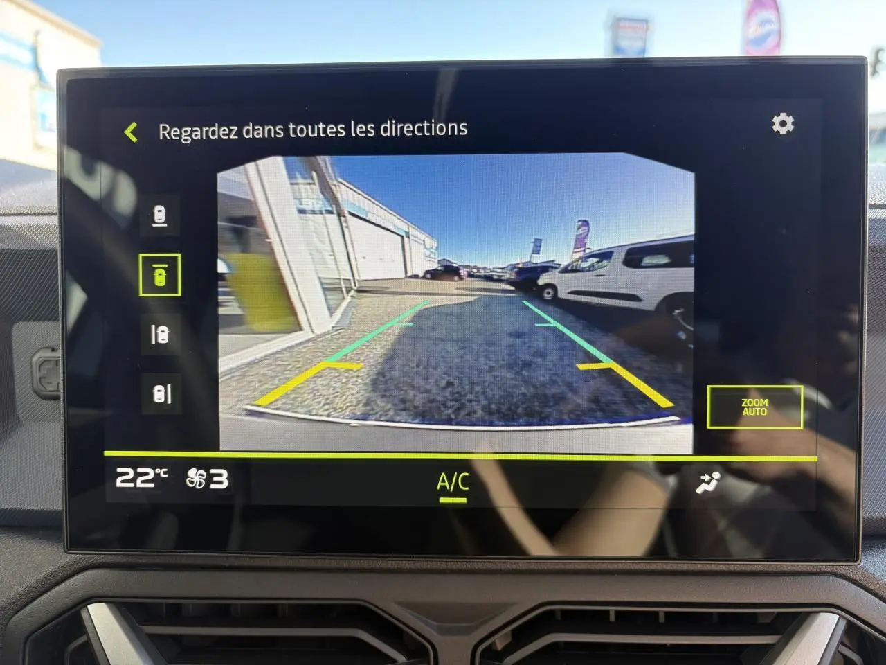 Vue écran caméra de recul du Dacia Duster blanc métallisé 2024, affichant l'arrière et l'environnement proche du véhicule.