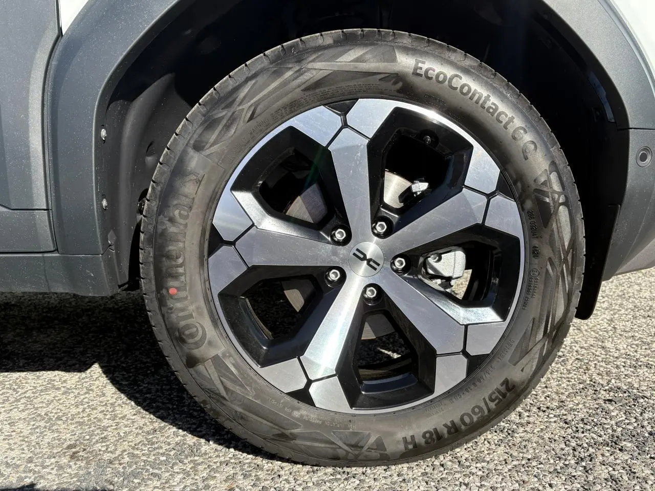 Gros plan sur la jante alliage 18 pouces du Dacia Duster blanc métallisé, avec pneu Continental EcoContact.