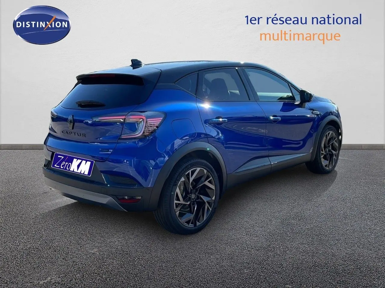 Vue 3/4 arrière droite d'un Renault Captur E-Tech hybride bleu Iron Metal avec toit noir et jantes noires.