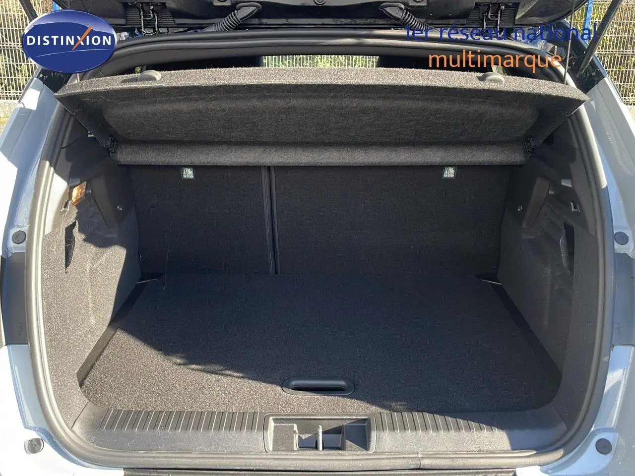 Coffre ouvert en vue arrière d'un Renault Captur gris Rafale métal avec toit noir, espace de chargement vide et propre.