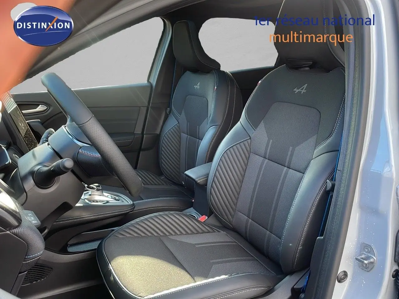 Vue intérieure côté conducteur du Renault Captur E-Tech gris rafale avec sièges Alpine en cuir noir et surpiqûres blanches.