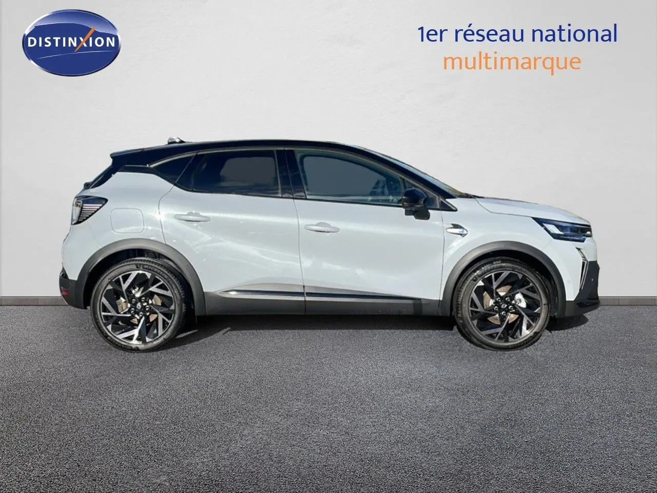 Profil latéral droit d'un Renault Captur E-Tech hybride gris rafale métal avec toit noir et jantes noires distinctives.