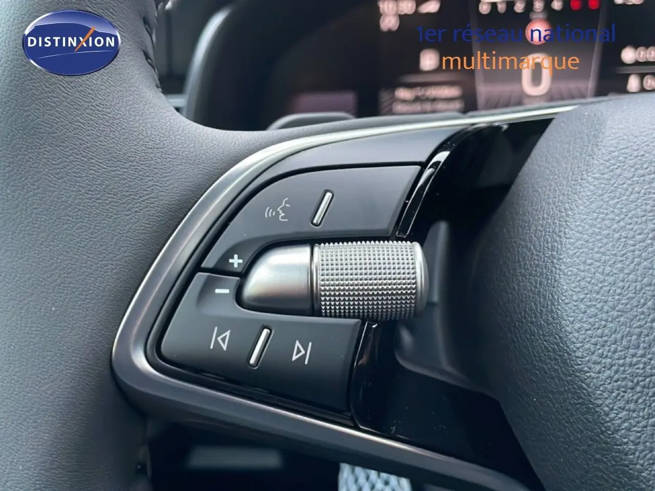 Gros plan sur les commandes audio au volant du Skoda Kamiq gris graphite, avec molette texturée et boutons multifonctions.