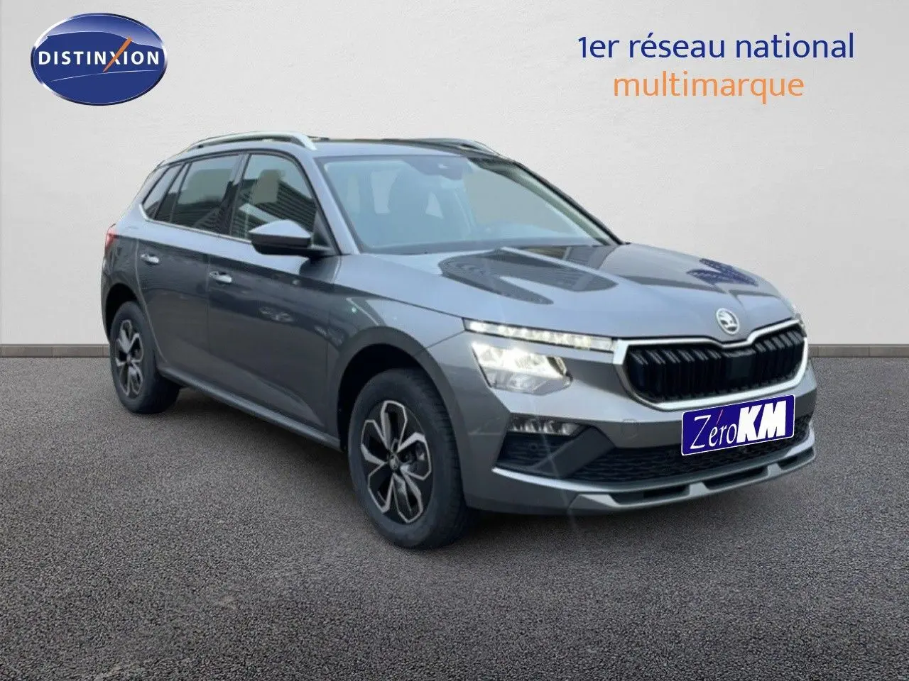 Vue 3/4 avant droit d’un Skoda Kamiq gris graphite métallisé avec calandre noire et jantes bi-ton.