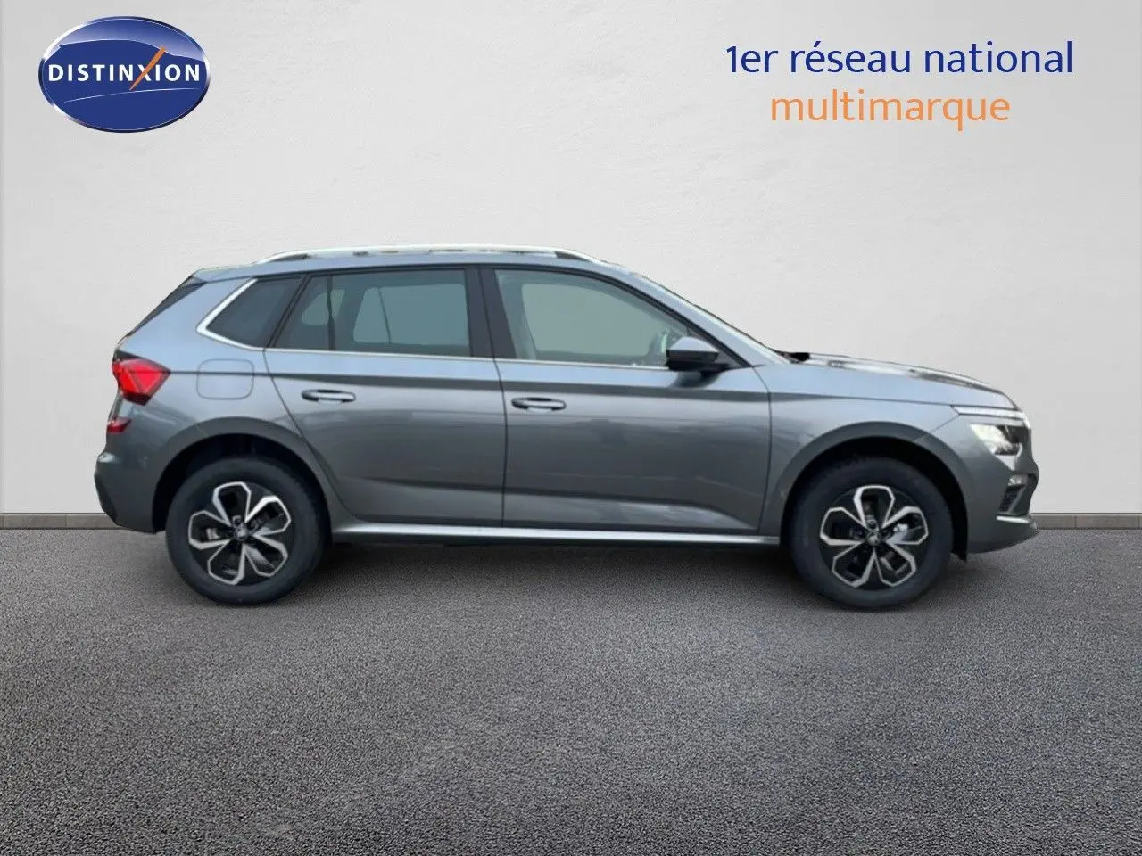 Vue latérale droite d'un Skoda Kamiq gris graphite métal, SUV compact avec jantes bi-ton et toit panoramique.