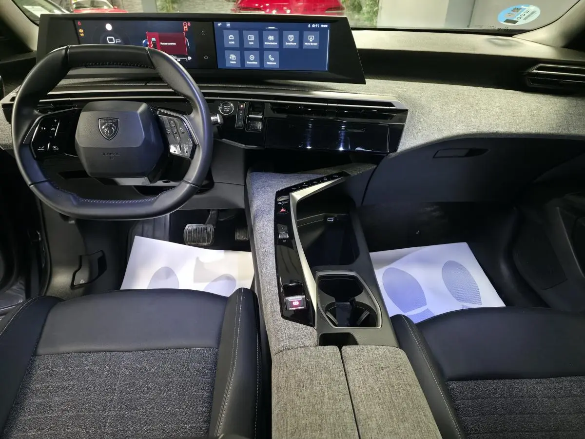 Intérieur avant du Peugeot 5008 2025, vue du conducteur, avec tableau de bord numérique et console centrale tissu gris.