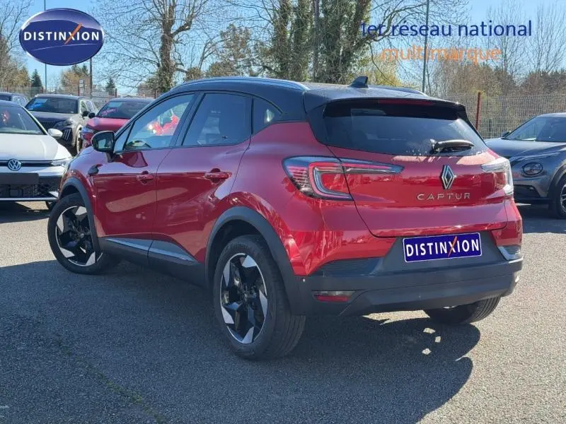Vue 3/4 arrière droite d'un Renault Captur 2025 Rouge Flamme avec toit noir et jantes noires distinctives.