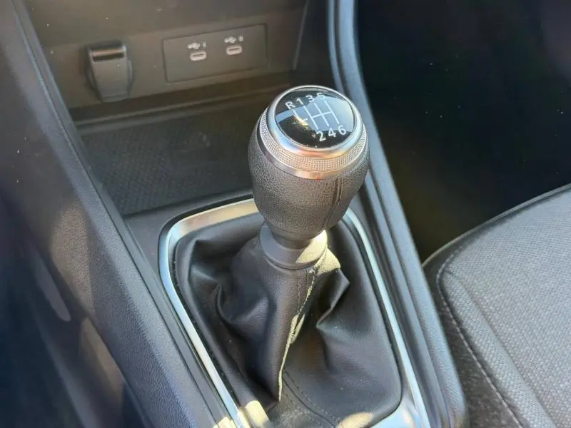 Gros plan sur le levier de vitesse manuel du Renault Captur 2025, entouré de garnitures noires et tissu gris du siège.