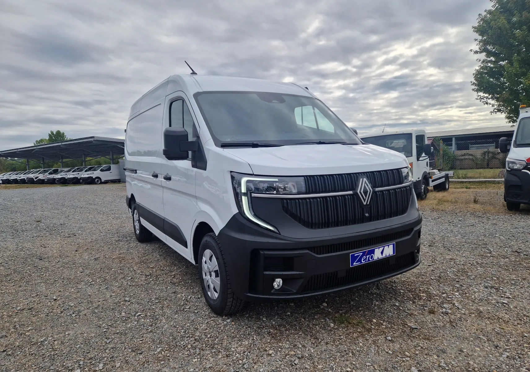 Renault Master blanc en vue 3/4 avant droit, avec calandre noire distinctive et plaque "Zero KM" visible.