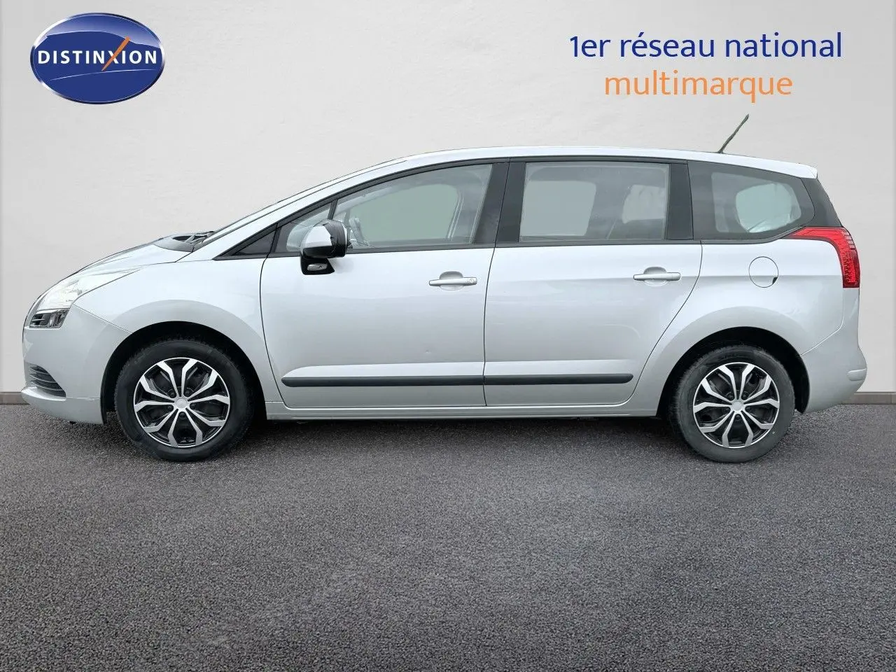 Peugeot 5008 gris en vue de profil côté gauche, montrant les jantes et les lignes latérales du véhicule.