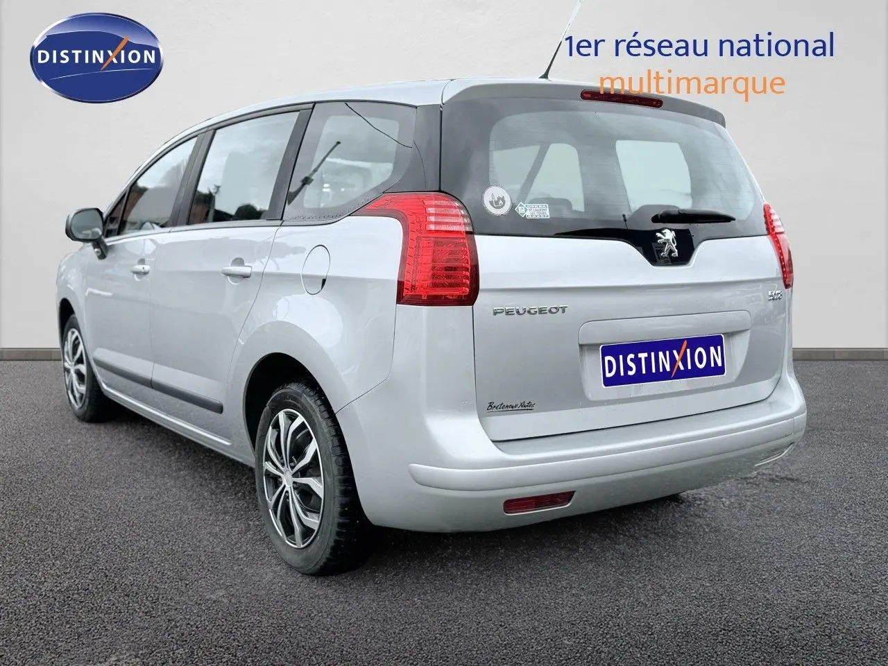 Vue 3/4 arrière droite d'un Peugeot 5008 gris avec hayon noir et feux arrière rouges.