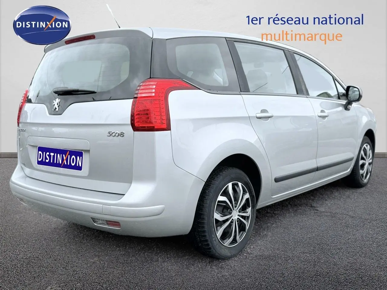 Vue 3/4 arrière droite d'un Peugeot 5008 gris 2010 avec hayon et feux arrière rouges visibles.