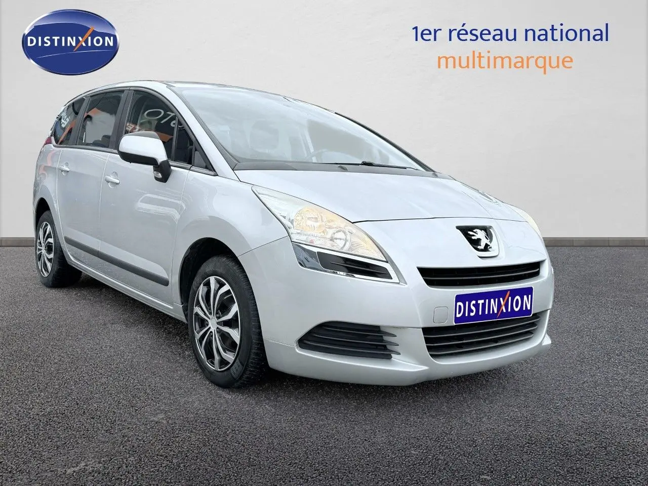 Peugeot 5008 gris vue 3/4 avant droit sur fond neutre avec jantes alliage et calandre distinctive.