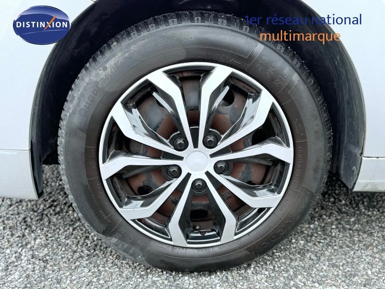 Gros plan sur la roue avant droite d’un Peugeot 5008 gris, mettant en valeur la jante alliage au design moderne.