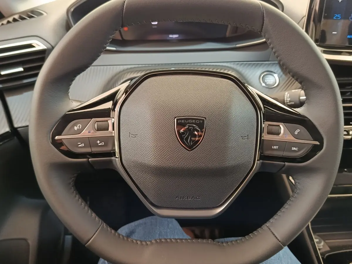 Volant cuir noir Peugeot 208 électrique 2024 vu de face avec commandes multifonctions intégrées.