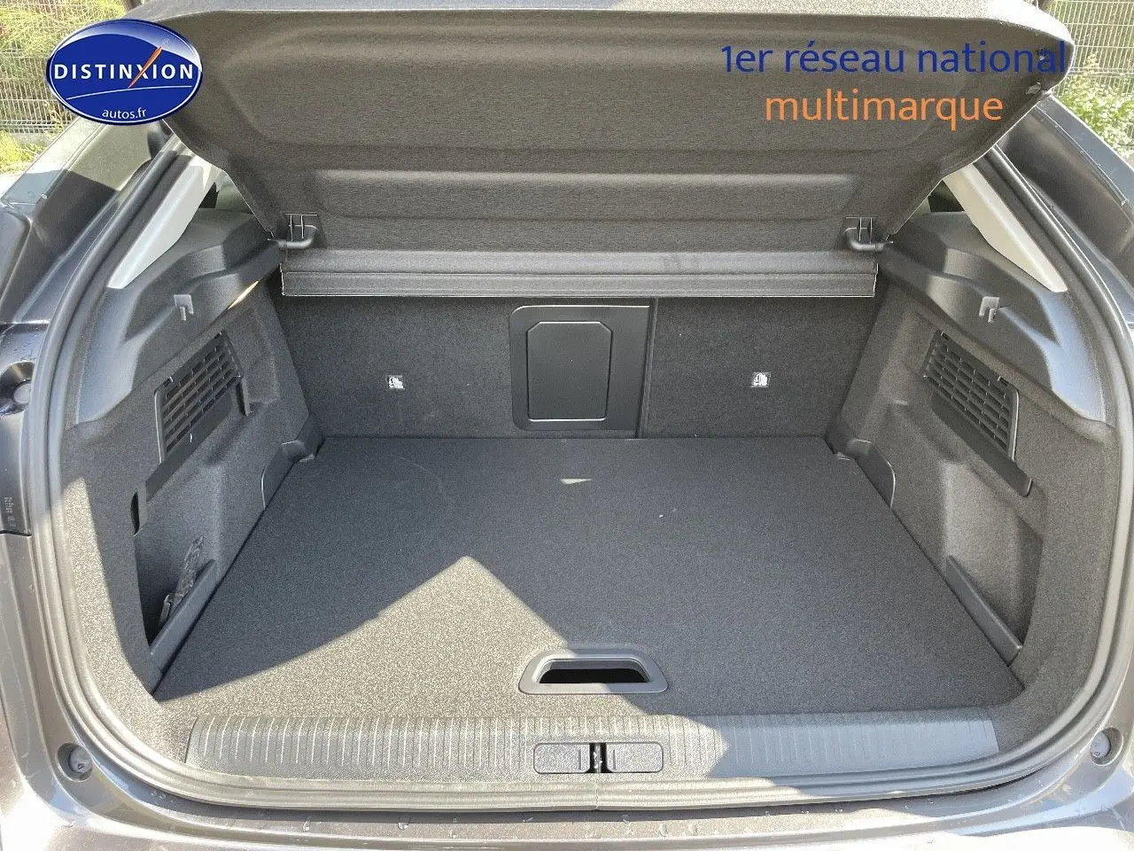 Coffre ouvert vu de l'arrière d'une Citroën C4 gris platinium métal, espace de chargement propre et spacieux.