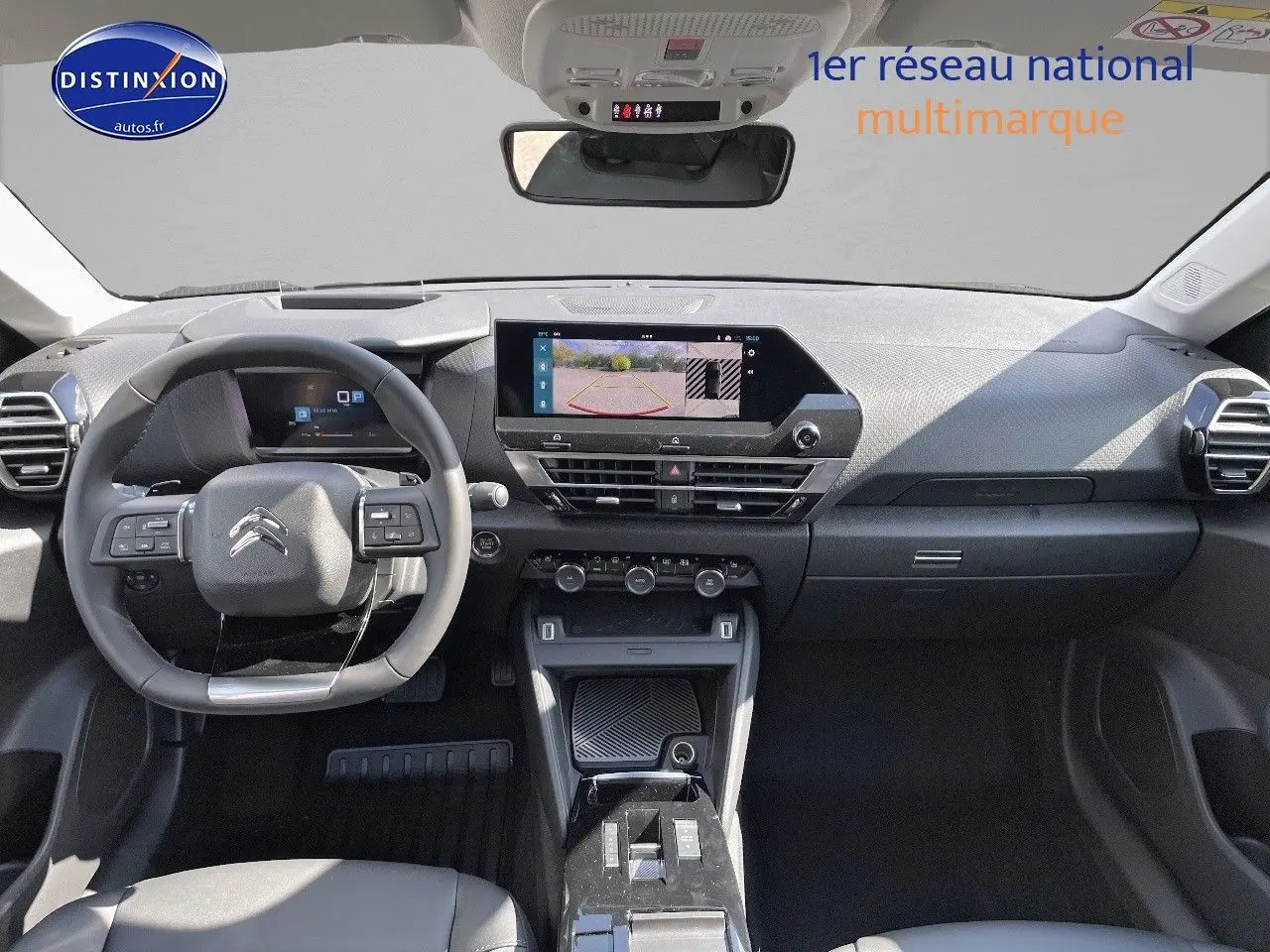Intérieur de la Citroën C4 2024 en gris platinium, vue frontale du tableau de bord avec écran tactile et volant multifonction.